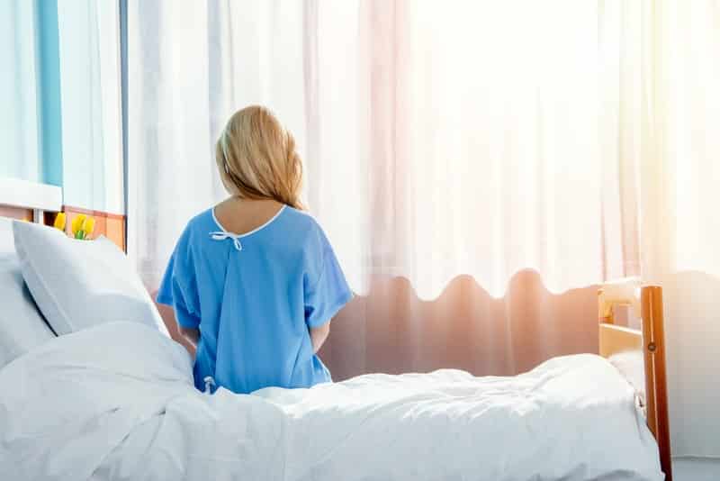 Woman-Sitting-on-Hospital-Bed